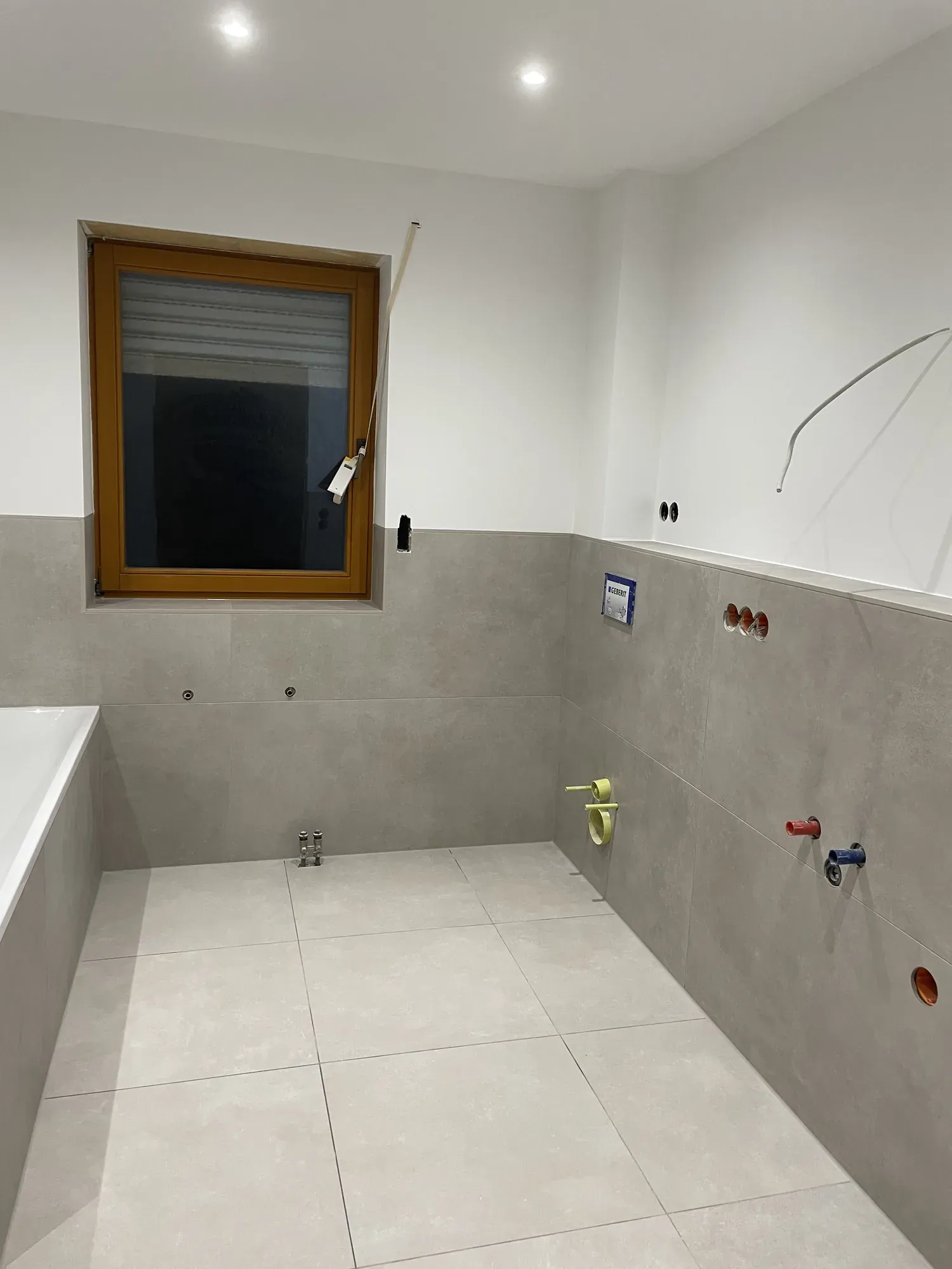 Detail der gefliesten Ablage an der Wanne mit Anschlüssen für die Armatur