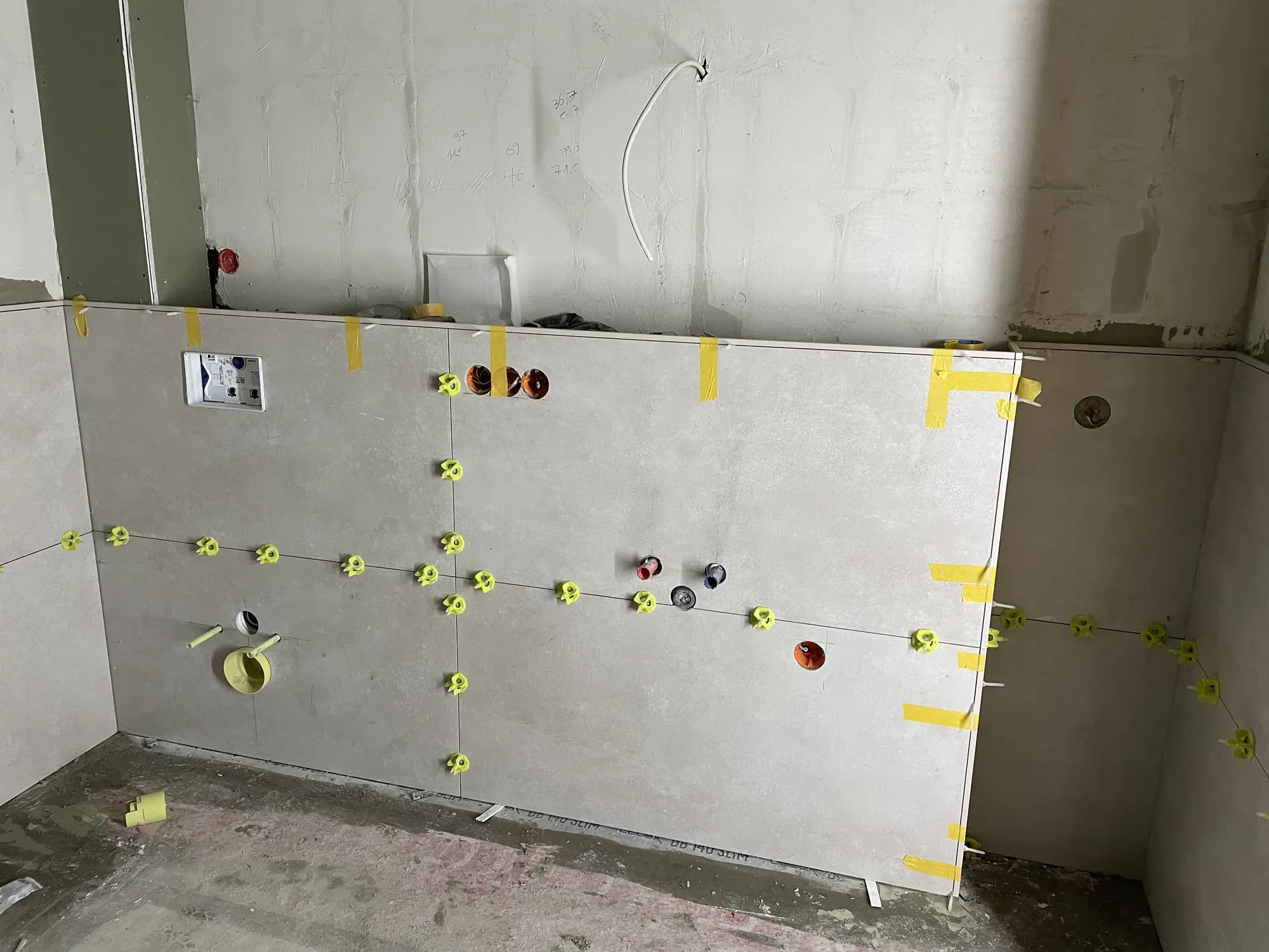 Neue Vorwand mit markierten Anschlüssen und ersten Wandplatten