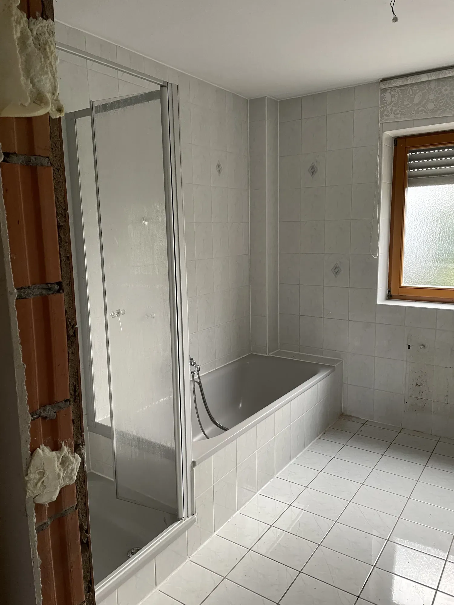 Altes Bad mit Duschkabine und Badewanne vor dem Rückbau