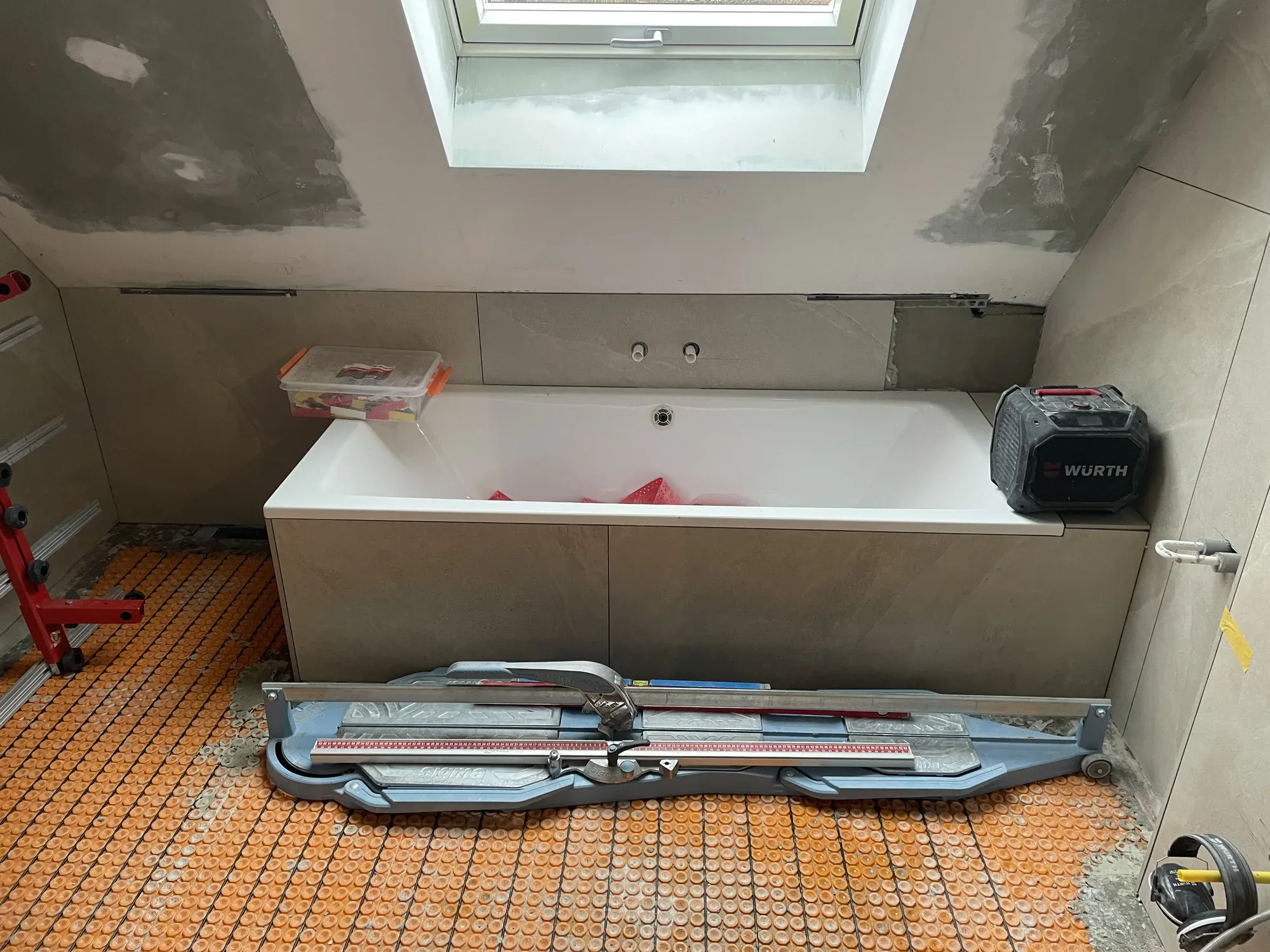 Badewanne wird mit Großformatfliesen verkleidet, Werkzeug auf dem Boden