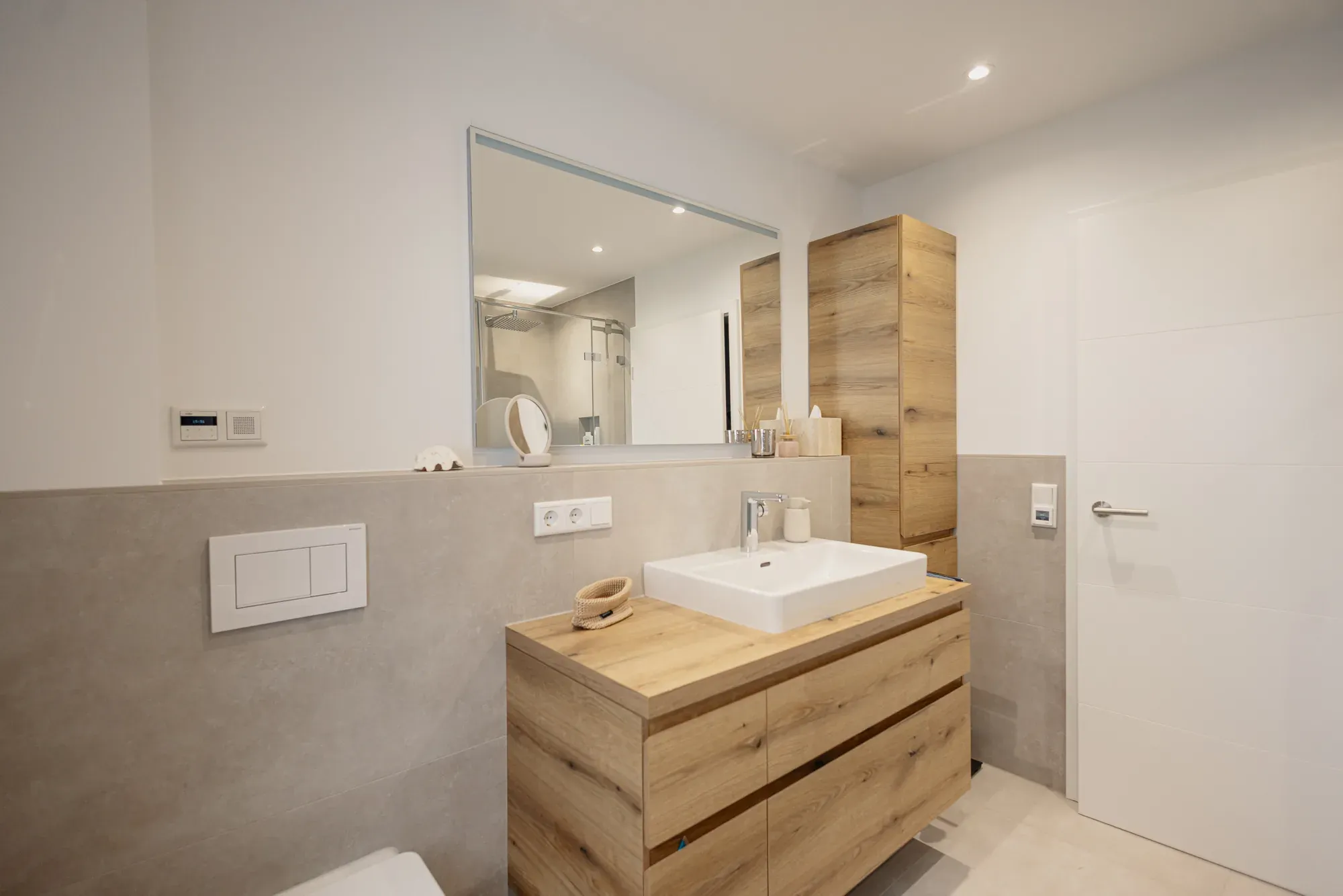 Saniertes Bad mit Eichen-Waschtisch, Wand-WC und Wand in Betonoptik