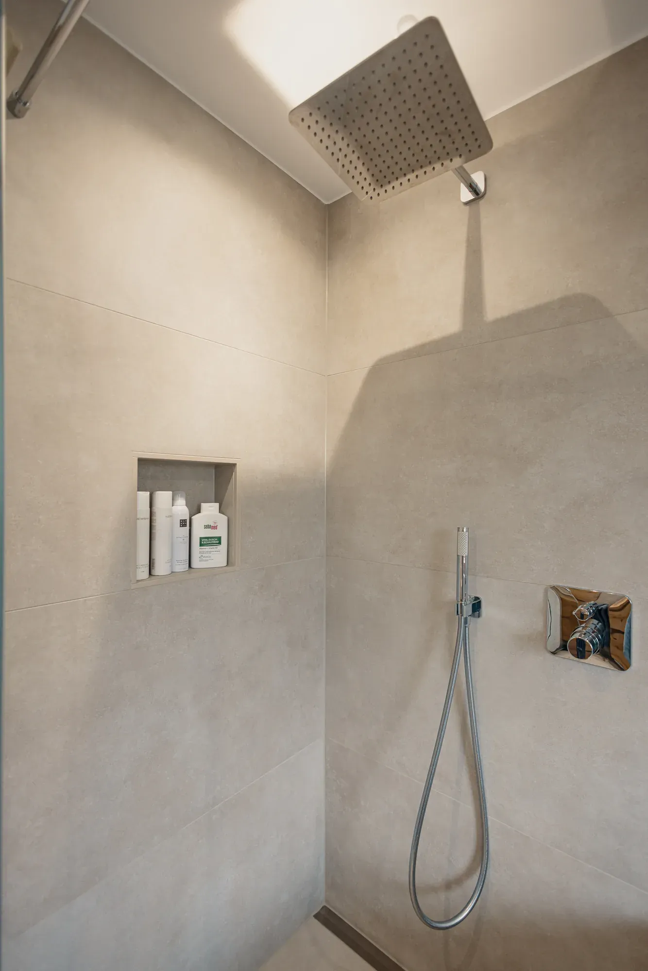Dusche mit Regenbrause, Handbrause und Nische in Betonoptik