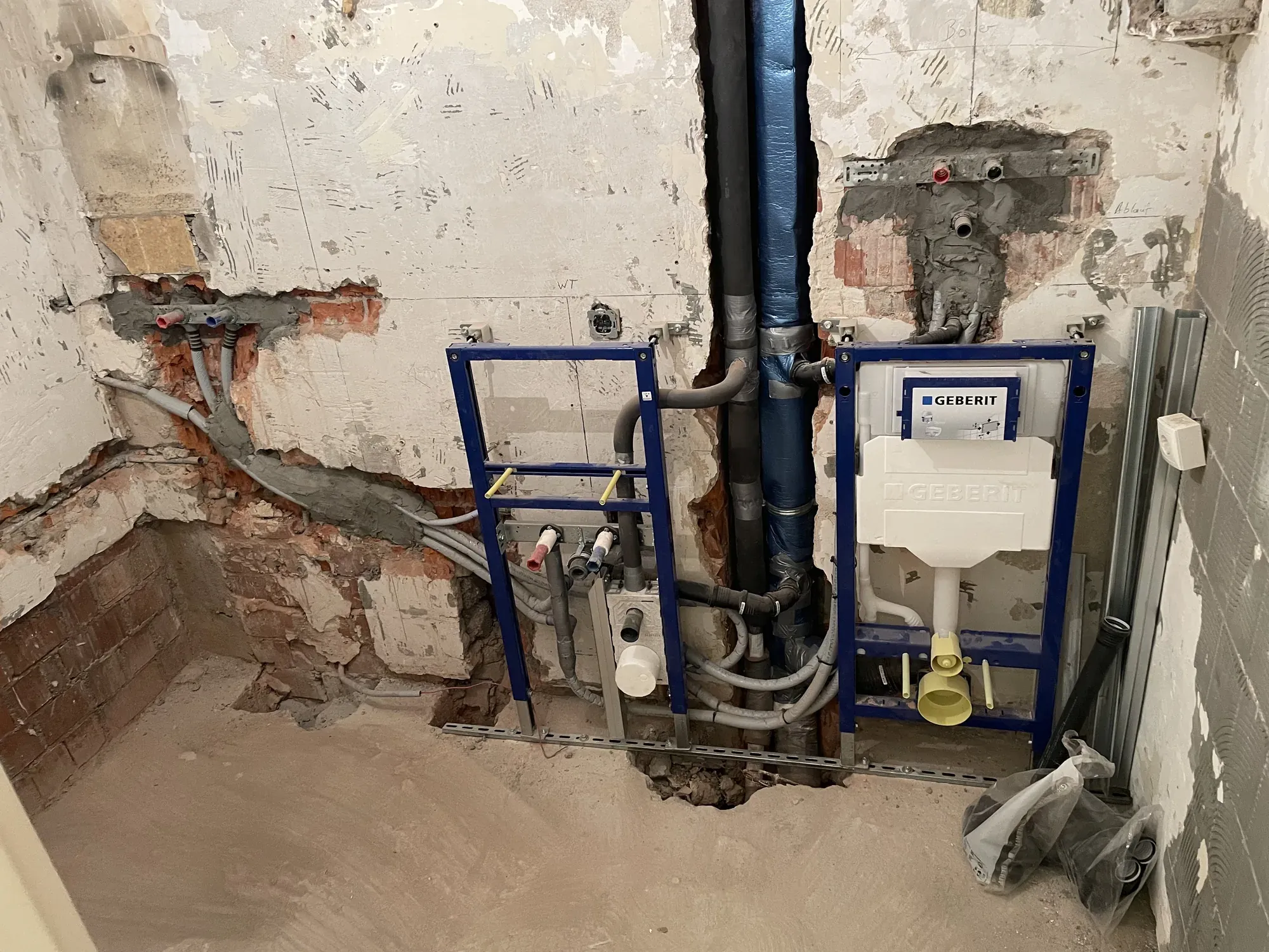 Vorwandinstallation mit WC-Element und Leitungen in einem entkernten Bad