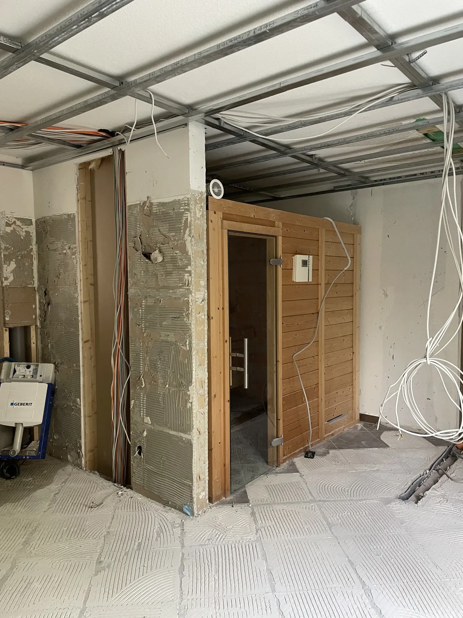 Entkerntes Bad mit abgeschlagenen Wänden und alter Sauna
